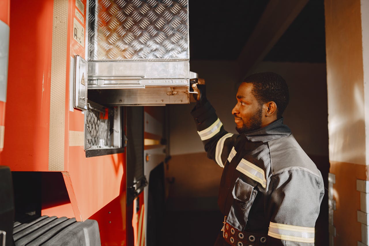 Services Close-up of a firefighter in uniform working with equipment on a fire truck.